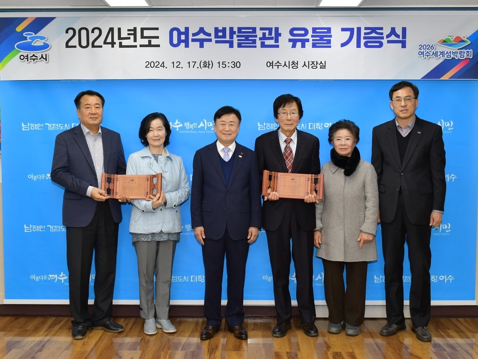 여수시청 시장실에서 2024년도 여수박물관 유물 기증식이 열리고 있으며, 참석자들이 기증된 유물을 들고 있다.