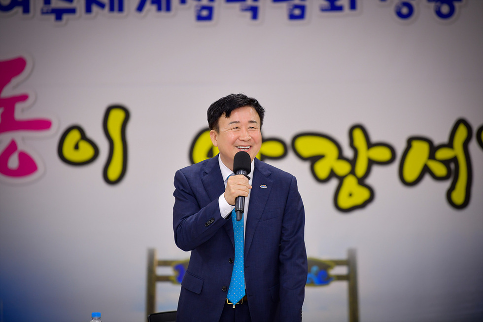 여수시청소년회관 개관식에서 한 남성이 마이크를 들고 웃으며 연설하고 있다.