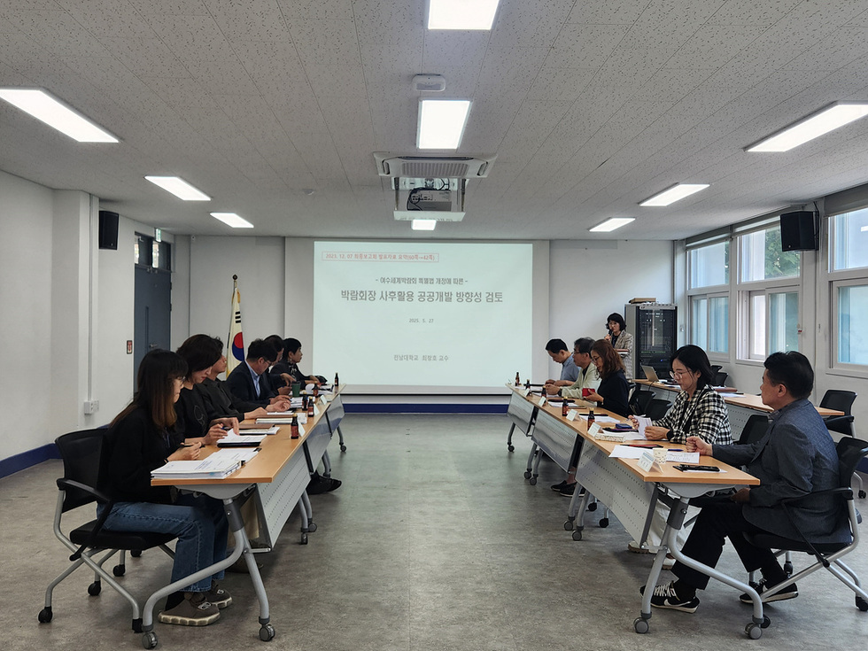 회의실에서 여러 사람들이 앉아 회의를 진행하고 있으며, 화면에는 박람회장 사무용 공간개발 방향성에 대한 발표가 진행되고 있다.