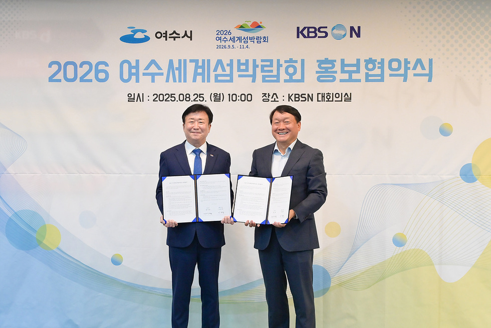 여수시와 KBS N이 2026 여수세계섬박람회 홍보협약을 체결하는 장면으로, 두 사람이 서명된 문서를 들고 있다.