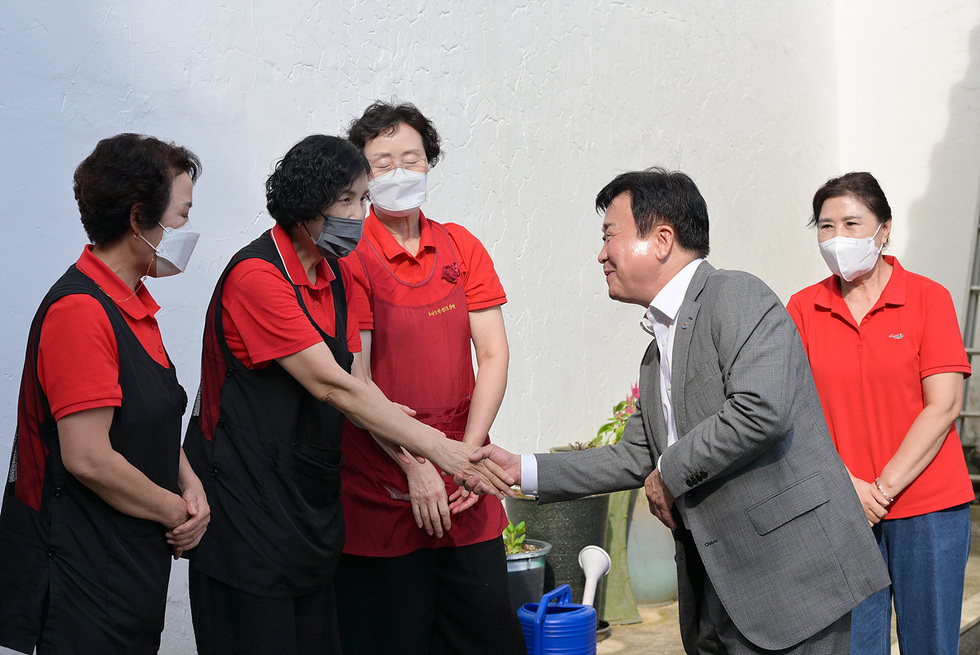 정기명 여수시장이 사회복지시설 종사자들과 인사를 나누고 있는 장면으로, 여수시의 추석 위문품 전달 활동을 보여준다.