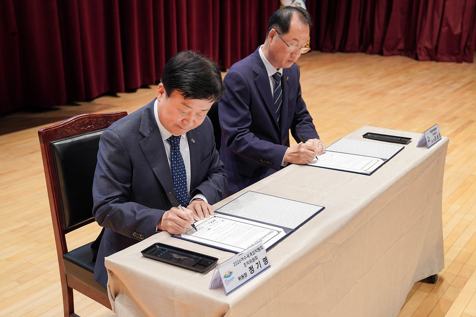 여수문화홀에서 정기명 위원장이 섬박람회 입장권 구매 약정식에 서명하고 있다.