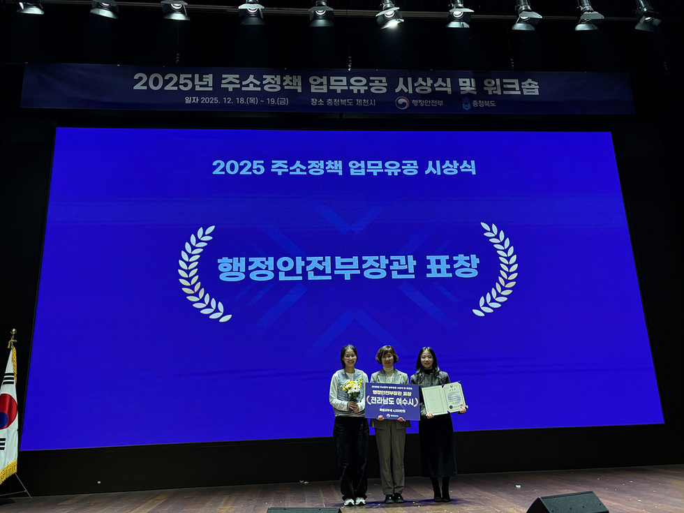 여수시가 지난 12월 18일 충청북도 제천시에서 열린 ‘2025년 주소정책 업무유공 시상식 및 워크숍’에서 우수기관으로 선정되었다. 사진은 시 관계자들이 ‘행정안전부장관 표창’과 ‘특별교부세 4,000만 원’이 표기된 기념 피켓을 들고 수상 기념촬영을 하는 모습.